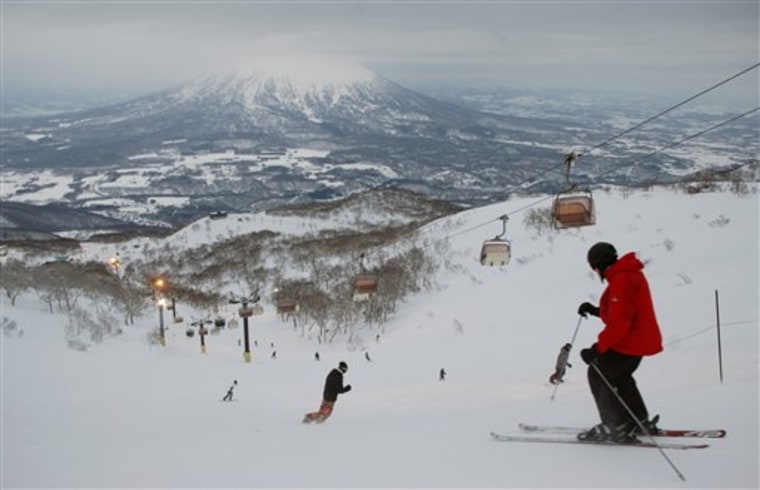 Skiers and snowboarders go down a slope in Niseko, Hokkaido, northern Japan, with Mount Yotei in the background. Foreign tourists and investors have flocked to scenic Niseko in recent years, giving this region a badly needed economic jolt.